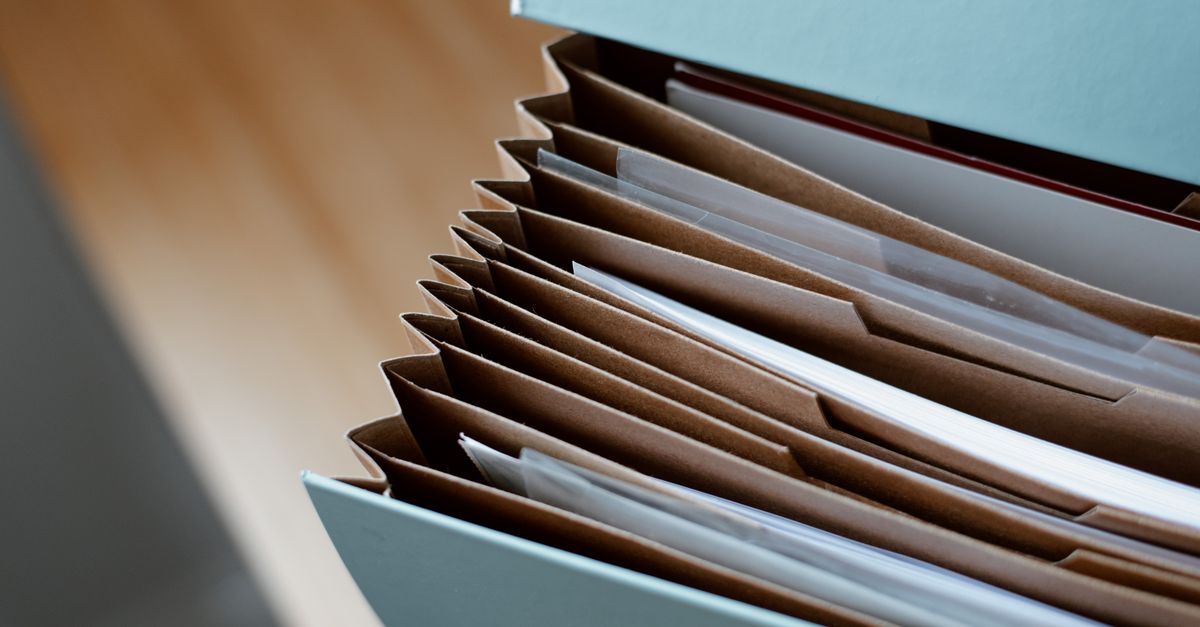 Carpetas y documentos antiguos apilados sobre una mesa de archivo