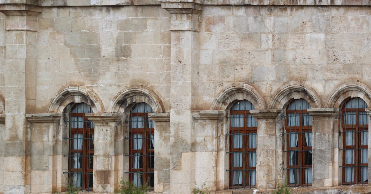 Fachada antigua de piedra con ventanas cerradas en un pueblo pequeño