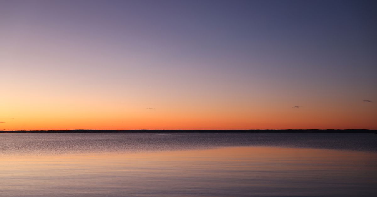 Mar en calma al atardecer con horizonte despejado